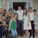 Patrícia e sua família na frente da nova casa ao lado do apresentador Celso Portiolli, Adriana, que doou o terreno e a equipe da empresa Mudar